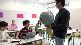 Geography educator pointing to globe while explaining world geography, highlighting continents and countries during interactive classroom lesson - Powered by Shutterstock - Get 15% off with code: PIKWIZARD15