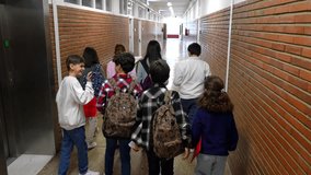 Diverse student group moving through school corridor between classes, portraying typical hallway interaction and academic transition during school day - Powered by Shutterstock - Get 15% off with code: PIKWIZARD15
