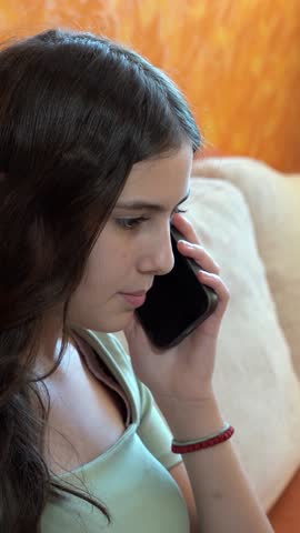 Portrait of a Smiling Teenage Girl Talking on Mobile Phone. Facial expressions reveal her positive emotions. Video is perfect for promotion of today's youth culture and using phones.