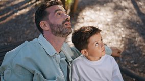 Interested father son looking distance at park weekend closeup. Caring dad pointing finger attracting attention of smiling child enjoying family moment at sunny forest. Happy man boy sitting bench - Powered by Shutterstock - Get 15% off with code: PIKWIZARD15