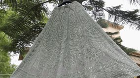 An elegant bridal gown draped outdoors, perfect for reception themes, slow-motion vibe - Powered by Shutterstock - Get 15% off with code: PIKWIZARD15