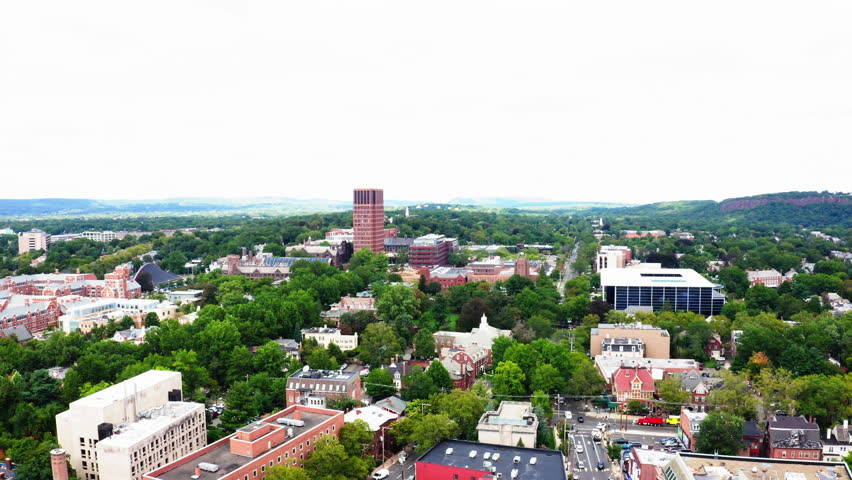 Static drone shot capturing the lush greenery, historic architecture, and modern skyline of New Haven, Connecticut, in vivid detail.