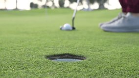 A person is standing on a golf course and preparing to hit a golf ball with a golf club - Powered by Shutterstock - Get 15% off with code: PIKWIZARD15