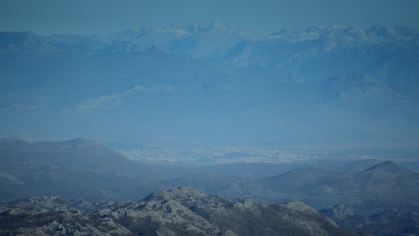 Stunning view showcases serene layered mountains enveloped in a soft blue haze, reflecting nature