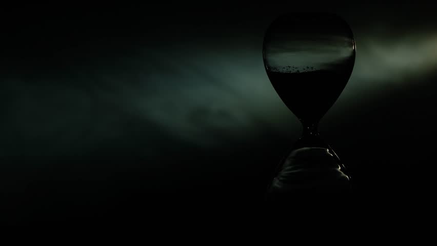 Light illuminates the hourglass. little grains of golden sand fall from above measuring the time. Time goes quickly. Time moves along. Sand Particles In Hourglass Sand Timer Clock. Sand falling. old