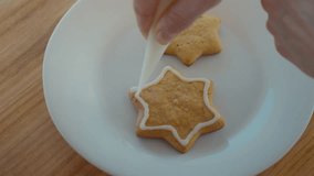 Baker pastry chef puts icing on christmas cookies fresh out of oven. Person makes cute star shaped cookies or biscuits by internet recipe - Powered by Shutterstock - Get 15% off with code: PIKWIZARD15