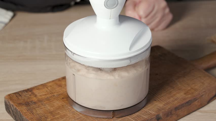 chef blending canned beans with garlic and lemon juice in blender in domestic home kitchen for making healthy vegan meal, food closeup