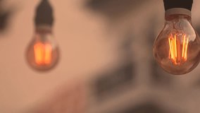 Two Edison-style light bulbs hanging from wires. The soft glow of the filaments inside the bulbs contrasts nicely with the fading blue sky. Vintage or cozy atmosphere. - Powered by Shutterstock - Get 15% off with code: PIKWIZARD15