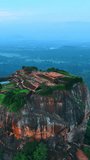 Tourists walk by the ruins of famous Sigiriya fortress in Sri Lanka. Drone footage around the rock revealing view of the stunning nature landscapes. Vertical video. - Powered by Shutterstock - Get 15% off with code: PIKWIZARD15