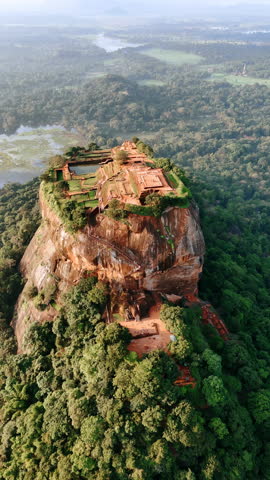 Ancient rock fortress near the town of Dambulla in the Central Province, Sri Lanka. Picturesque mount in the lush tropical forests. Top view. Vertical video.