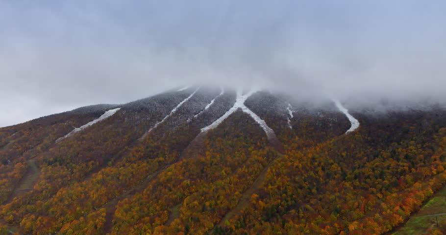 Mountains of Vermont, New England, USA on a grey autumn day. Thick fog covers the rock top. Aerial view.