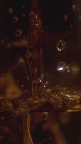 Close-up of whiskey with an ice cube, a natural and cold alcoholic beverage, a beautiful decoration and light, a crystal glass. slow motion, 4K.