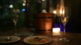 Romantic Dinner Setting with Dim Lighting Featuring Wooden Table, Gourmet Food, Champagne Glasses, Candle, and Wooden Ice Bucket in Cozy and Intimate Ambiance - Powered by Shutterstock - Get 15% off with code: PIKWIZARD15