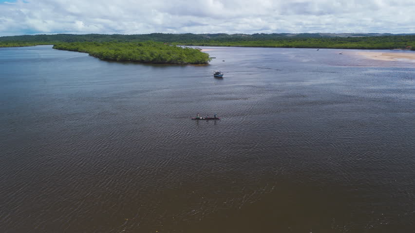 Panoramic drone shot circling a fishing boat on the De Contas river in Brazil