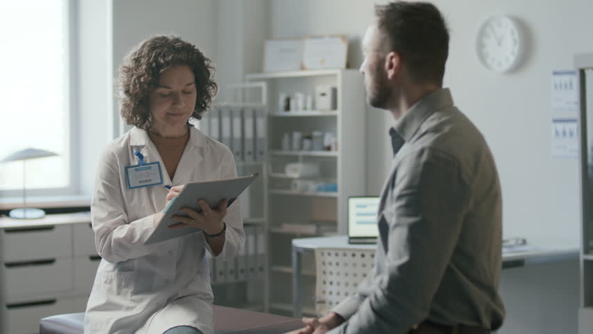 Female doctor asking patient questions, listening attentively and taking notes during medical appointment in clinic - Powered by Shutterstock - Get 15% off with code: PIKWIZARD15