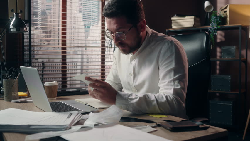 Frustrated upset Caucasian male accountant reading bills man stress employee leader executive guy headache businessman counting expenses in office company finance trouble manager agent business outlay