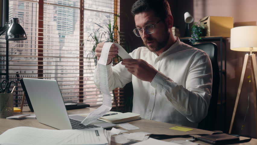 Frustrated upset Caucasian male accountant reading bills man stress employee leader executive guy headache businessman counting expenses in office company finance trouble manager agent business outlay