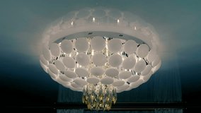Beautiful modern fashionable ceiling chandelier sparkling with its glass elements. Closeup. Macro. Shallow depth of field. Shot in motion - Powered by Shutterstock - Get 15% off with code: PIKWIZARD15