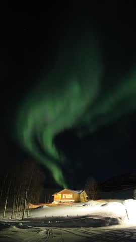 Real video of the green Aurora Borealis dancing across the night sky above the Arctic Circle in northern Norway. Vertical 4k video