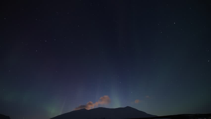 Breathtaking time-lapse of the Aurora Borealis dancing across the dark sky over the mountains in Northern Norway, in the Tromsø region. A horizontal 4K video