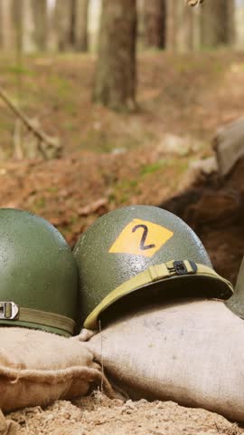 WWII American Metal Helmets Of United States Army Infantry Soldier At World War II. Helmets Near Camping Tent In Forest Camp.