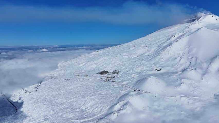 Shot during a snowfall in the tourist area of ​​Etna Sud on the Etna volcano. Snow-covered woods, Piano Vetore, Sapienza Refuge. Frozen cottage. Frozen trees. Snow storm.