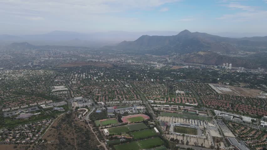 Urban santiago chile cityscape with cerro san cristobal hill showing stadium, buildings and mountains in the background