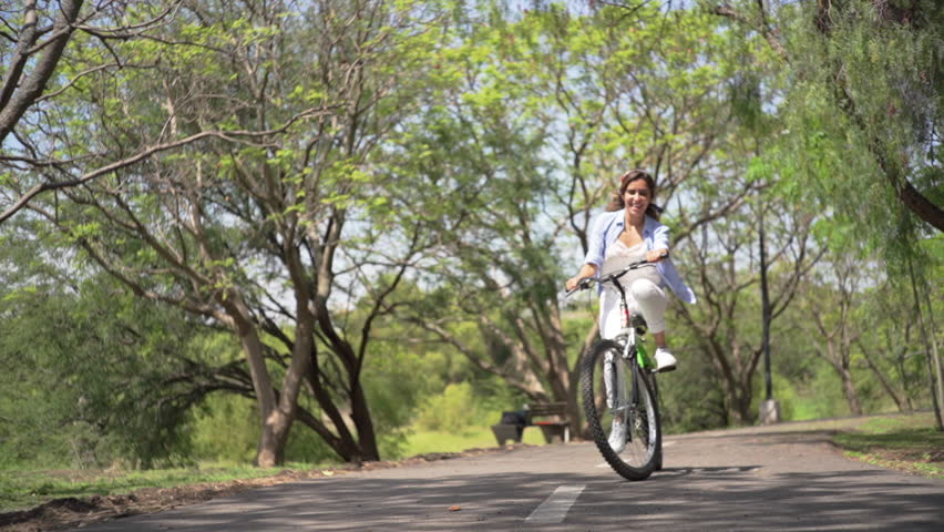 Young woman riding in the park on a bicycle.