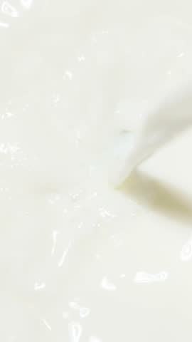 Pouring milk in slow motion. Vertical video