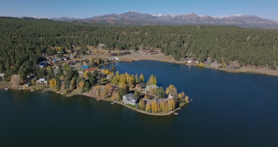 A scenic aerial view of Pagosa Springs, Colorado, showing a lake surrounded by autumn trees