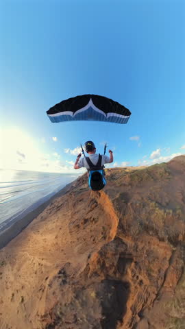 Paraglider soaring in New Zealand coast at sunset, adventure concept.