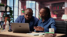 Mature couple dealing with online banking together at home in their loft, setting up payments and confirming money transfer. Pleased man and woman enjoy online shopping on laptop. Camera B. - Powered by Shutterstock - Get 15% off with code: PIKWIZARD15