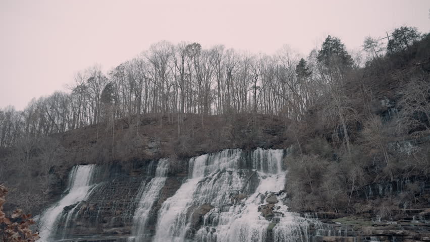 Large waterfall cascading down a cliff in the hills of Tennessee during the winter