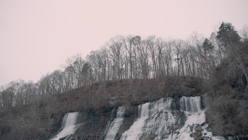 Large waterfall cascading down a cliff in the hills of Tennessee during the winter