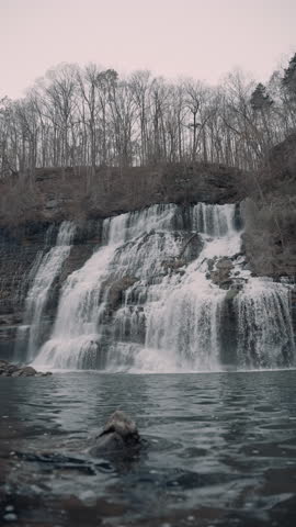 Large waterfall cascading down a cliff in the hills of Tennessee during the winter