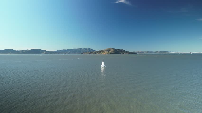 Aerial drone shot of Treasure Island with a boat in the day and the North Pacific Ocean in California, USA