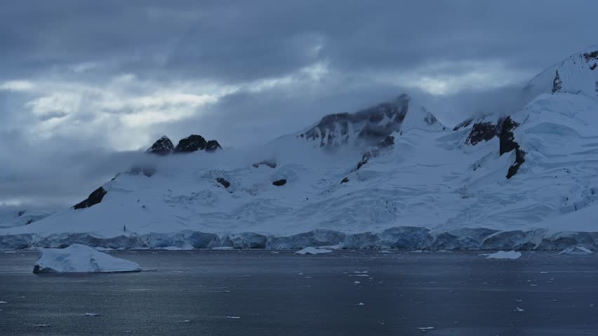 Winter Mountains Coastal Scenery in Antarctica, Dramatic Clouds and Sky in Cold Dark Blue Landscape with Glaciers and Ocean Sea Water on Coast, Antarctic Peninsula Seascape in Moody Atmospheric Scene