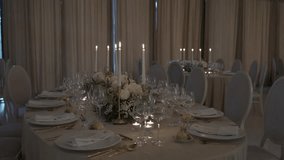 Elegant dinner table with glowing candles, white floral centerpieces, and fine dining setup - Powered by Shutterstock - Get 15% off with code: PIKWIZARD15