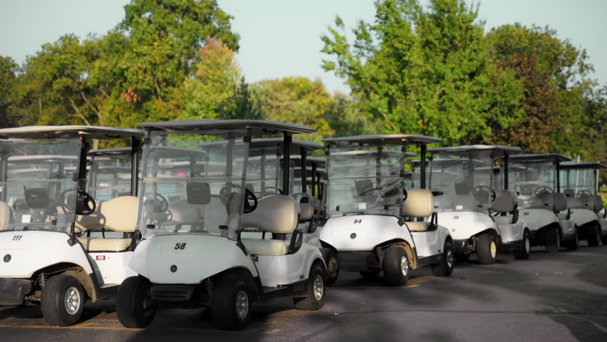 Golf carts parked in a designated area at a golf club. Neatly arranged electric vehicles ready for players to use on the course