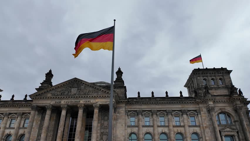 Reichstag building or Bundestag with glass Dome and German Flags in Berlin, Germany, video 4k