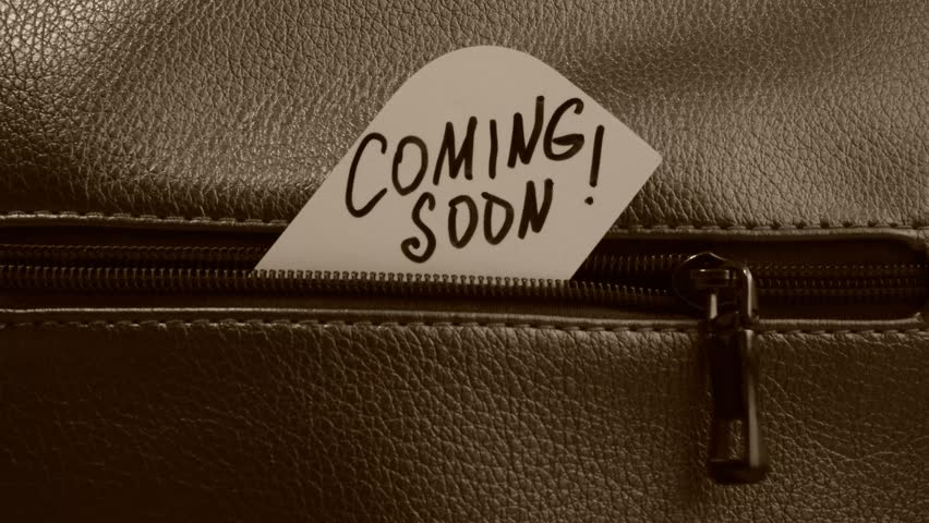Text Coming Soon on paper. Close up of zip on dark textured leather. Grunge style	