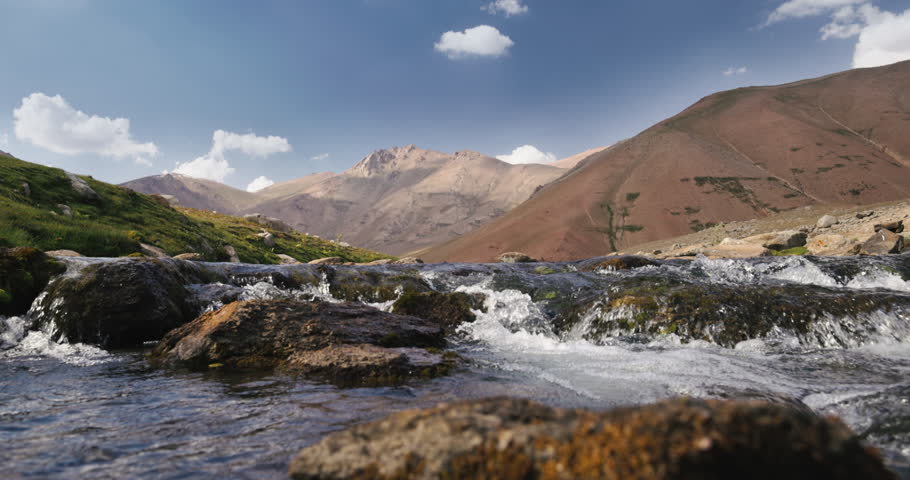 Mountain stream slow motion. Arashan. Spring mountain stream. Water flows over rocks covered with moss. Camera movement from top to bottom. Joyful peaceful cinematic wilderness. No people