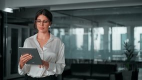 Hispanic mature professional business woman looking at pc and using app. European businesswoman CEO holding digital tablet working fintech tab application standing at workplace in office. Copy space - Powered by Shutterstock - Get 15% off with code: PIKWIZARD15