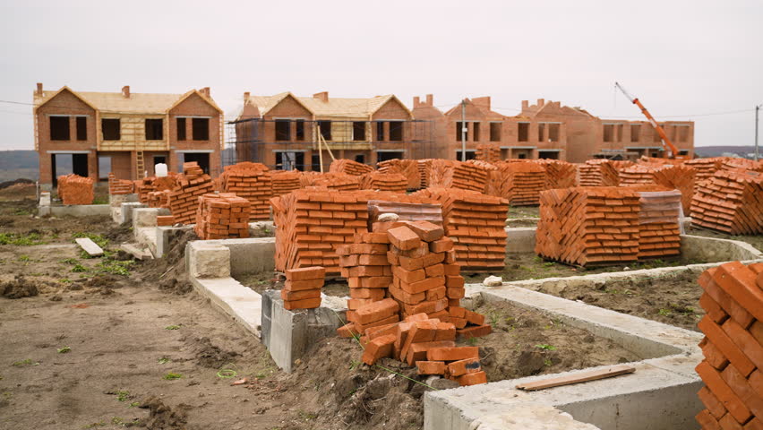Townhouse construction site with stacked bricks and foundations