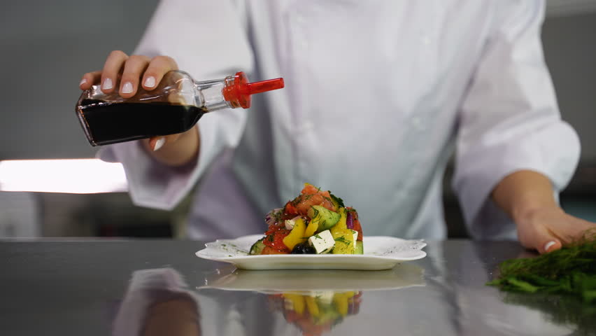 Pouring balsamic vinegar or soy sauce on fresh vegetable salad