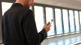 Professional businessman navigating airport terminal, walking on moving walkway while checking smartphone, embodying modern business travel connectivity - Powered by Shutterstock - Get 15% off with code: PIKWIZARD15