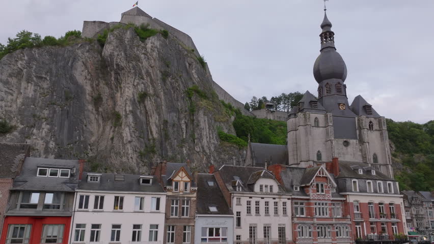 Charming scenes of Dinant, Belgium, reveal the stunning Collegiate Church of Our Lady and the historic Citadel rising majestically atop a steep cliff