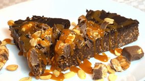 Delicious chocolate Snickers cake with lots of peanuts topped with melted caramel - Powered by Shutterstock - Get 15% off with code: PIKWIZARD15