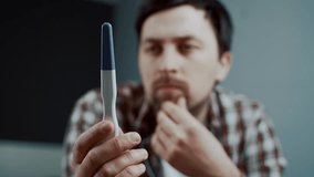 A man stares at a pregnancy test handed to him by his wife, holding his head in frustration. His emotions reflect disappointment and concern, clearly showing his unease about the unplanned pregnancy.  - Powered by Shutterstock - Get 15% off with code: PIKWIZARD15