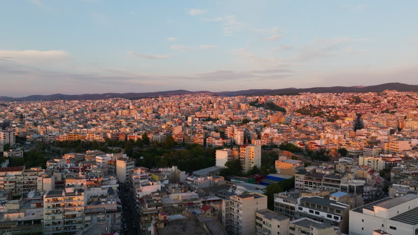 Aerial view of Thessaloniki, Greece, during sunset. The city is bathed in golden light, creating a warm and inviting atmosphere in Southern Europe